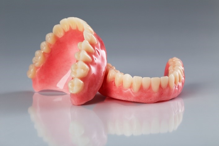 A Pair of Dentures Resting on a Gray Surface Representing Dental Solutions in Stittsville, ON