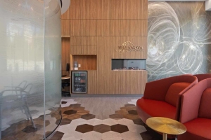 Modern dental lobby with wood accent wall, curved seating, and artistic feature wall at the Terry Fox office in Ottawa, ON