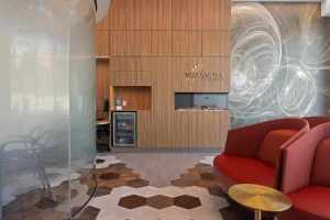 Modern dental reception area with wood panel walls, glass partition, and seating in Terry Fox Office.