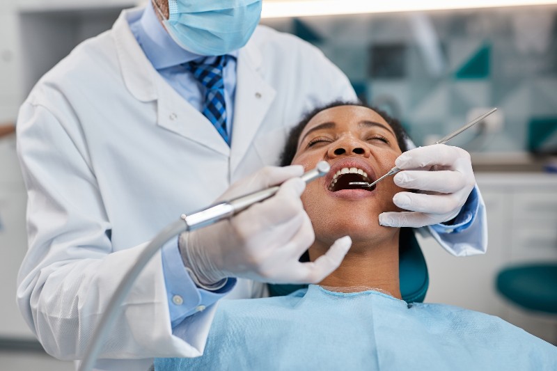 A woman getting a dental check-up with dental tools in her mouth by Villanova Dental Studio