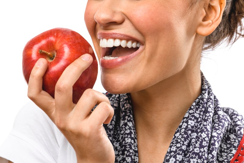Woman smiling and holding an apple in Stittsville and Kanata, ON